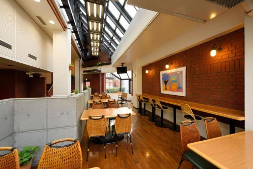 a restaurant with tables and chairs and a brick wall at Morioka New City Hotel in Morioka