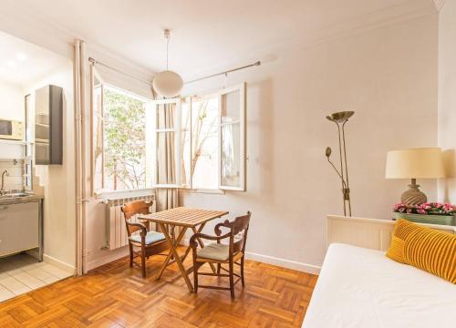 un salon avec une table et des chaises et une cuisine dans l'établissement FLEUR- Cosy Studio, 200 Promenade des Anglais et Negresco, wifi, climatisation- calme, à Nice