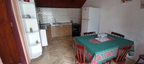 a kitchen with a table with a green table cloth at Cabañas Brisa's in Santa Vitória do Palmar