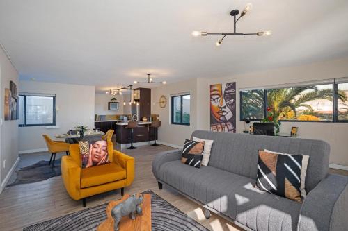 a living room with a couch and a yellow chair at Knightsbridge Terrace in Cape Town