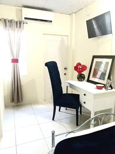 a room with a desk and a chair and a window at The Hibiscus Retreat in Arima
