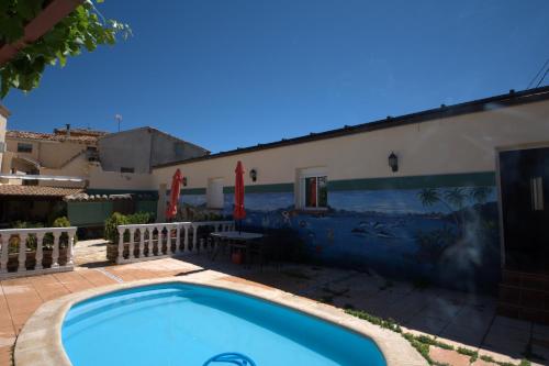una piscina frente a un edificio con un mural en Entrefrutales, en La Vilueña