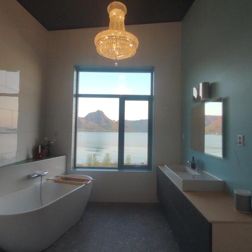 a bathroom with a large window and a large tub and sink at Villa by the sea in Vesterålen 