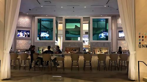 a restaurant with people sitting at a bar with televisions at Vista Balcony Collection - StripSuite Palms Place Hotel, Resort & Casino in Las Vegas