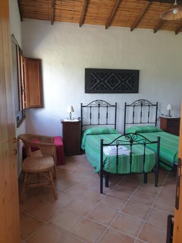 Un dormitorio con dos camas y una mesa y una silla. en Agriturismo Villino Elena, en Piscinas