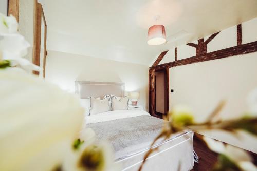 a bedroom with a bed with white sheets and pillows at Cottage near Matlock Bath & Cromford in Middleton