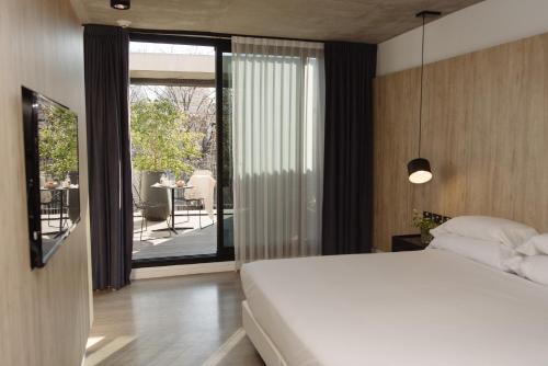 a bedroom with a large white bed and a balcony at Krista Boutique Hotel in Buenos Aires
