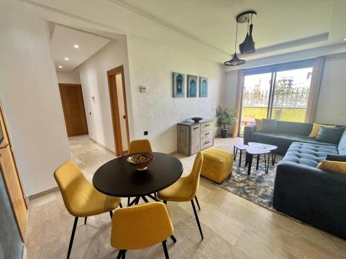 a living room with a couch and a table and chairs at Appartement Agadir Bay , 3 chambres, piscine et jardin in Agadir