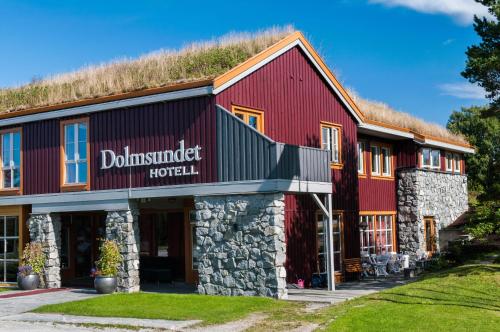 a red barn with a grass roof at Dolmsundet Hotell Hitra in Melandsjøen