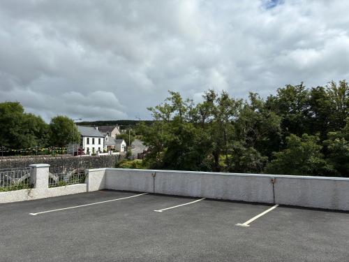a parking lot with a white house in the background at Carrick Gate in Carrick