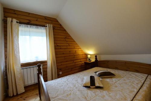 a bedroom with a bed with a phone on it at Sodyba Tarp Liepų in Leliūnai