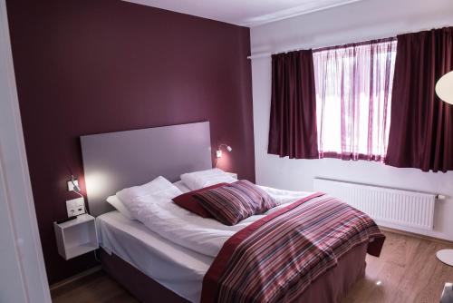 a bedroom with a bed with white sheets at Dolmsundet Hotell Hitra in Melandsjøen