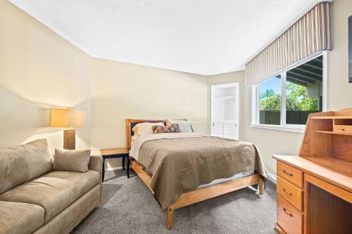 a bedroom with a bed and a couch and a window at Fairway Forest Retreat! in Welches