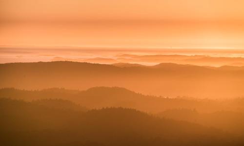 a foggy valley with mountains in the distance at sunset at Dolmsundet Hotell Hitra in Melandsjøen