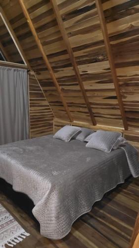 a bed in a room with a wooden ceiling at Tierra de Ensueño Glamping in Ibagué