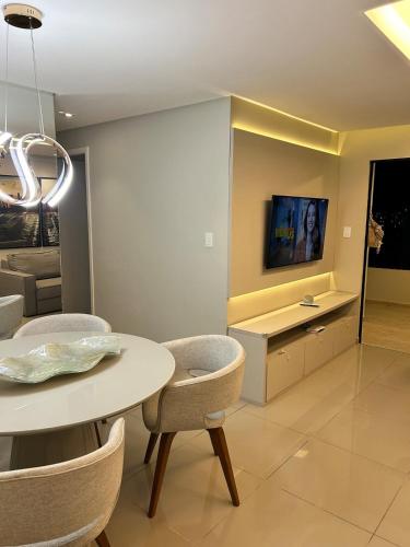 a dining room with a table and a tv on a wall at Charme com vista pro Rio, excelente localização in Petrolina