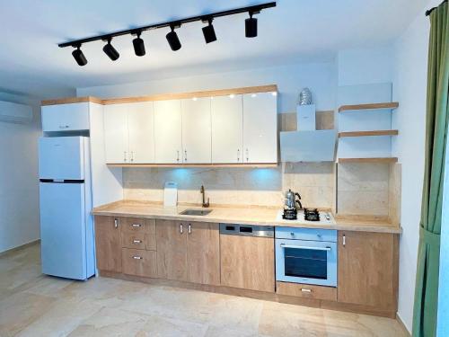 a kitchen with wooden cabinets and a white refrigerator at Çam Tatil Evleri in Datca