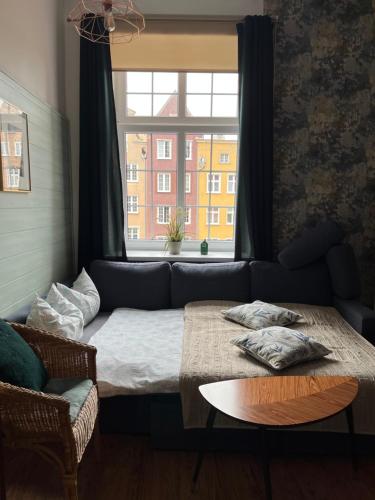 a living room with a couch and a window at Apartament Piwna52 in Gdańsk
