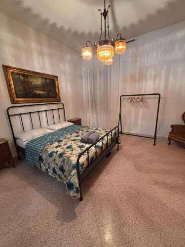 a bedroom with a bed and a chandelier at ADAapartmenthousesalerno in Salerno