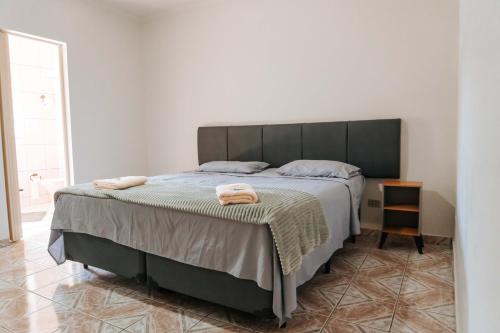 カブレウーヴァにあるHotel Pousada Villa Itália - Cabreúvaの大きなベッドとタオル2枚のある寝室