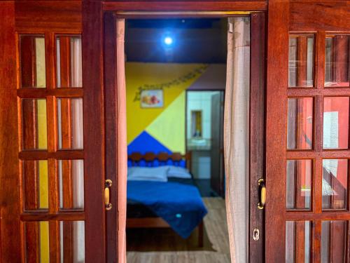 a view of a bedroom through a glass door at Chêles - Casa na Praia do taquari in Paraty