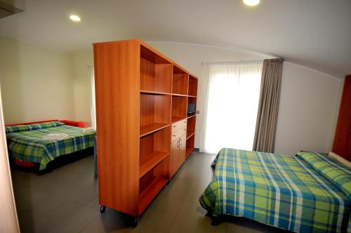 sypialnia z drewnianą szafką i 2 łóżkami w obiekcie 7venti w mieście Francavilla al Mare