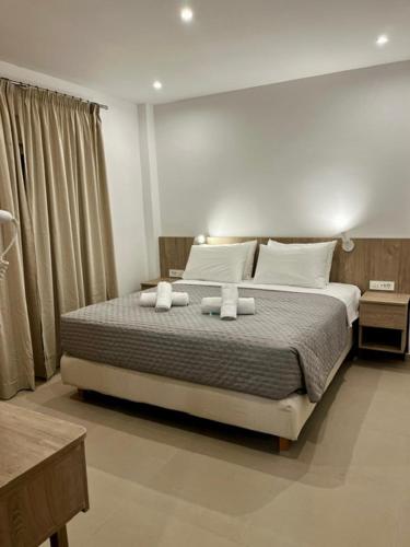 a bedroom with a large bed with two towels at Your Second Home in Kefalos