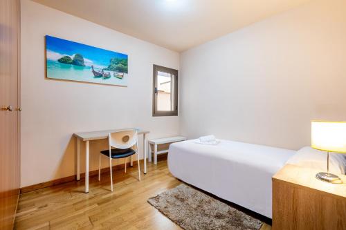 a bedroom with a bed and a desk and a table at Luminoso piso en La Laguna by CABANA Rentals in La Laguna