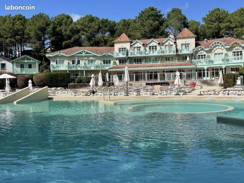 un grande edificio con una piscina d'acqua di fronte di T2 Lacanau Océan Piscine Golf a Lacanau-Océan