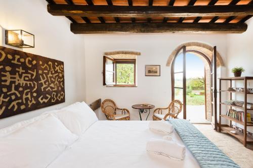 a bedroom with a white bed and a table at Il Paglieto - Natura, Stelle, Relax e Piscina in Manciano