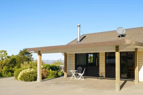 a house with a porch with a table and chairs at Treetops in Blenheim