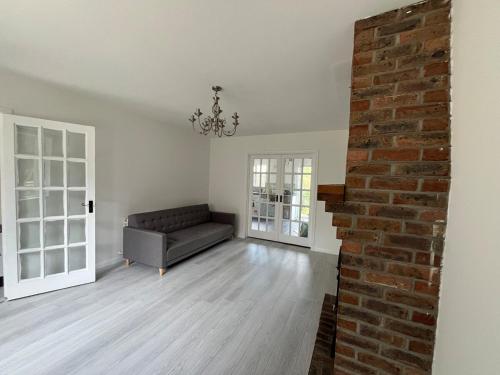 a living room with a couch and a brick wall at Villa nxt Rock, Cashel & palace in Cashel