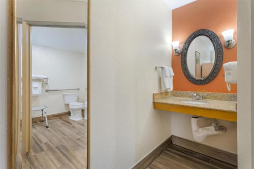 a bathroom with a sink and a mirror and a toilet at Best Western Dulles Airport Inn in Sterling