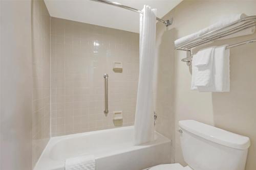 a white bathroom with a shower and a toilet at Best Western Dulles Airport Inn in Sterling