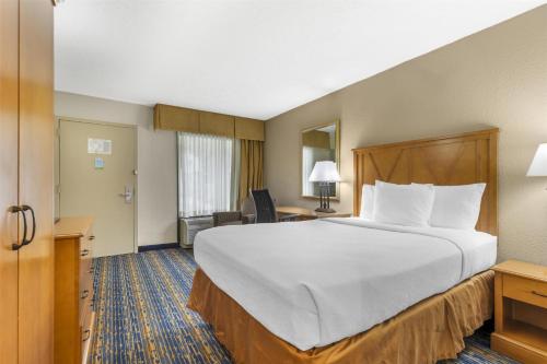 a hotel room with a large bed and a desk at Best Western Dulles Airport Inn in Sterling