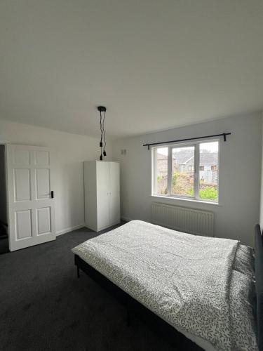 a white bedroom with a bed and a window at Villa nxt Rock, Cashel & palace in Cashel