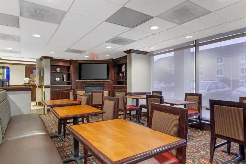 a restaurant with tables and chairs and a flat screen tv at Best Western Dulles Airport Inn in Sterling