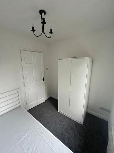 an empty bedroom with a white cabinet and a chandelier at Villa nxt Rock, Cashel & palace in Cashel