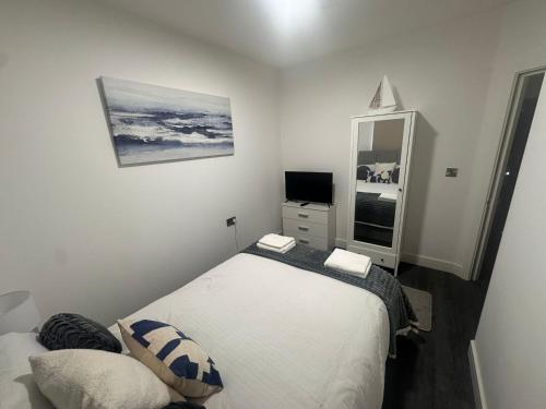 a bedroom with a bed and a dresser with a television at Liverpool RD Warrington in Great Sankey