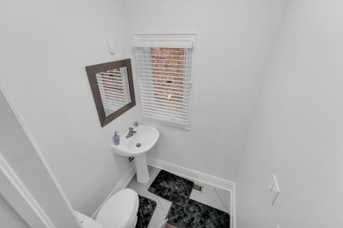a white bathroom with a sink and a toilet at Spacious 5-Bedroom Family Home in GTA in Milton