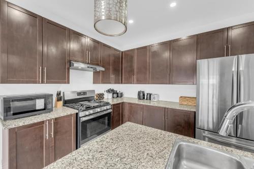 a kitchen with wooden cabinets and stainless steel appliances at Spacious 5-Bedroom Family Home in GTA in Milton