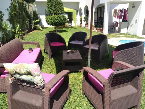 a group of chairs and tables on the grass at Magnifique villa Olfa in Hammamet