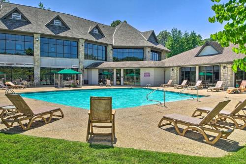 a swimming pool with chairs and a building at Whispering Creek - In the Heart of Ozarks Near Downtown in Reeds Spring