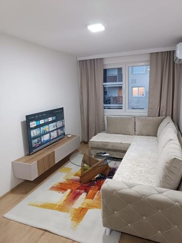 a living room with a couch and a flat screen tv at Holiday2 Konjic Apartment in Konjic