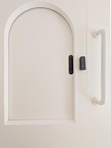 a white door with a window and a remote control at Brimfield Stay in Los Angeles