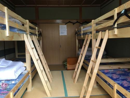 a room with four bunk beds in a room at Towadako Hostel in Towada