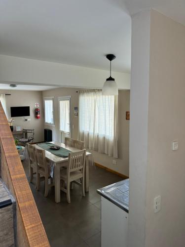 Una cocina y un comedor con mesa y sillas. en Casas Antares, en Villa La Angostura
