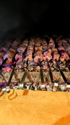 a row of meat being cooked on a grill at B&B Cottage in Mestia in Mestia