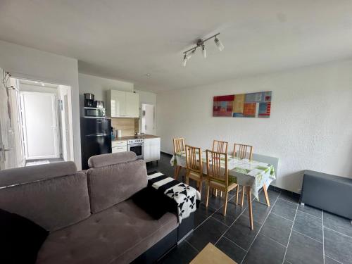 a living room with a couch and a table and a kitchen at Mauves et Marées plage à 300m in Saint-Hilaire-de-Riez