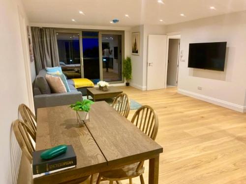 a living room with a table and chairs and a couch at Luxury Penthouse 3-Bedrooms Private in London